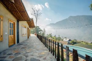 a house with a balcony with a view of a mountain at Supan Ecolodge in Sa Pa