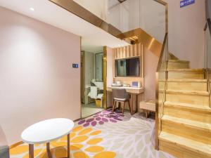 uma sala de estar com uma escada e uma secretária em Lavande Hotel Beijing Yizhuang Development Zone JD Headquarter em Daludian