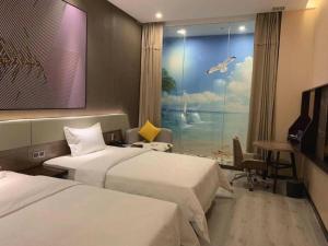武漢的住宿－IU Hotels· Wuhan Jianghan Road Metro Station，酒店客房设有两张床和窗户。