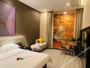 a bedroom with a bed and a desk and a table at IU Hotels· Wuhan Jianghan Road Metro Station in Wuhan