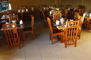 a dining room with wooden tables and chairs at Ol Moran Tented Camp in Ololaimutiek