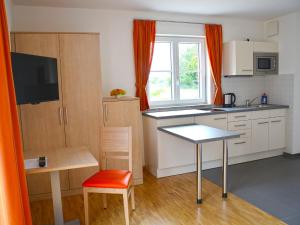 a small kitchen with a table and a table sidx sidx sidx at Apparthotel Ampertal in Kranzberg
