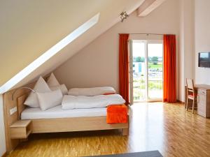a bedroom with a bed and a staircase with red curtains at Apparthotel Ampertal in Kranzberg
