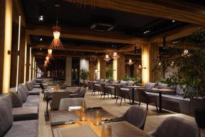 a restaurant with tables and chairs in a building at Wood Hotel Resort & SPA in Bukovel