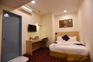 Habitación de hotel con cama y escritorio en hotel bintang, en Kuala Lumpur