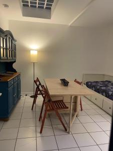 - une cuisine avec une table en bois et un lit dans l'établissement T2 sur cour au coeur des JO 2024, à Saint-Denis
