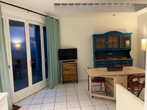 a room with a desk and a tv and a table at T2 sur cour au coeur des JO 2024 in Saint-Denis