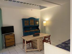 a room with a desk and a cabinet and a tv at T2 sur cour au coeur des JO 2024 in Saint-Denis