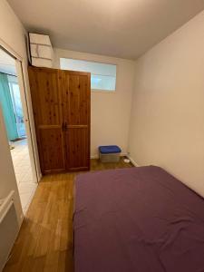 - une chambre avec un lit et une porte en bois dans l'établissement T2 sur cour au coeur des JO 2024, à Saint-Denis