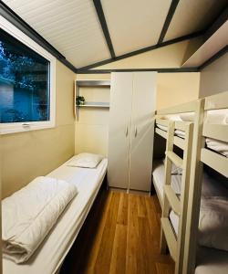 a small room with two bunk beds and a window at Le Chalet de Louise 7 places in Taradeau