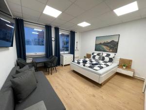 une chambre avec un lit et un salon avec un canapé dans l'établissement Smart In Göttingen - Apartments & Rooms, à Göttingen