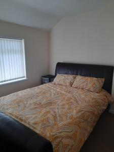 1 dormitorio con 1 cama grande con manta marrón en Entire Three Bedroom House in Birmingham en Birmingham
