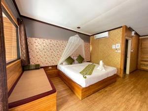 a bedroom with a bed with a green pillow on it at The Hub Erawan Resort in Chongsadao