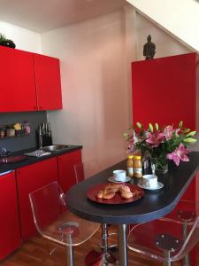 a kitchen with red cabinets and a table with a plate of food at Cannes Centre Palais du Festival in Cannes