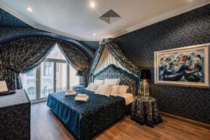a bedroom with a blue bed and a painting on the wall at Celine Residence Luxury in Budapest