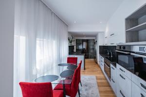 cocina con sillas rojas y mesa de cristal en Celine Residence Luxury, en Budapest