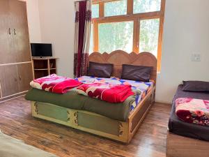 - une chambre avec un grand lit et une fenêtre dans l'établissement Safarnama Homestay Leh - Best Rooms in Leh with Parking, à Leh