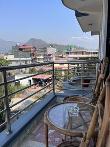 een balkon met twee stoelen en een glazen tafel bij Hotel Pokhara View backup in Pokhara