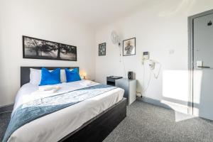 倫敦的住宿－Ryam Suites，一间卧室配有一张带蓝色枕头的大床