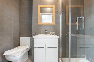 a bathroom with a toilet and a sink and a shower at Ryam Suites in London