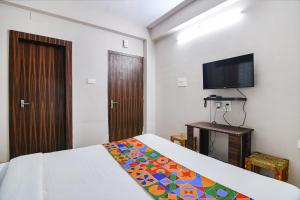 a bedroom with a bed and a flat screen tv at FabHotel White House I in Jojera