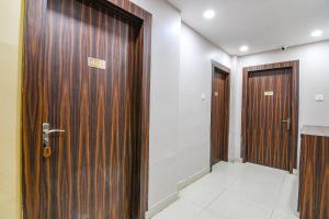 a corridor with two wooden doors in a room at FabHotel White House I in Jojera