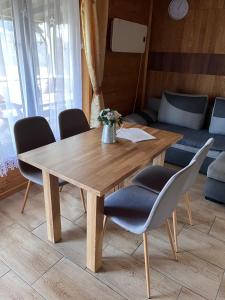 a wooden table and chairs in a room at Domki Dwa in Limanowa