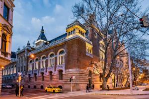 um edifício com um carro amarelo estacionado em frente dele em Celine Residence Luxury em Budapeste