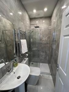 a bathroom with a shower and a toilet and a sink at F3, Luxury Flat close to Ilford. sel in Ilford