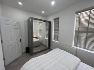 a bedroom with a mirror and a bed in it at F3, Luxury Flat close to Ilford. sel in Ilford