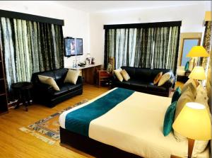 a hotel room with a bed and a living room at Gomang Boutique Hotel in Leh