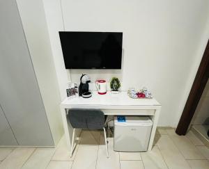 a white desk with a television on a wall at ImeraRooms in Rome