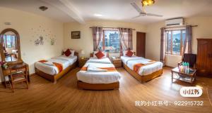 een hotelkamer met drie bedden en een tafel bij Hotel Pokhara View backup in Pokhara