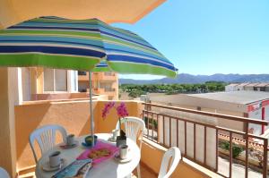 une table avec un parasol sur un balcon dans l'établissement RNET - Studio Olympe - Roses Costa Brava, à Roses