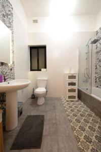 La salle de bains est pourvue de toilettes, d'un lavabo et d'une douche. dans l'établissement Cozy 3 Bedrooms - Near Sliema Seafront, à Sliema