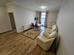 ein Wohnzimmer mit einem Sofa und einem Tisch in der Unterkunft Restauracja & Hotel Polowczyk 