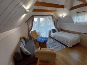 a attic room with a bed and a couch at Willa Jack in Władysławowo