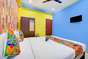 a bedroom with two beds with colorful pillows at FabExpress Nest in Kolkata