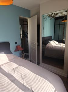 ein Schlafzimmer mit einem Bett und einem großen Spiegel in der Unterkunft 40m2 flat - 10 min Parc des Princes / Trocadero in Paris