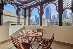a table and chairs with a view of the city at Burj khalifa view 1BR Souk al Bahar Tajer Residences Mint avenue Downtown Golden Homes in Dubai