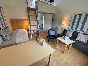 - un salon avec un lit, un canapé et un escalier dans l'établissement Sankt Helene Holiday Center, à Tisvildeleje
