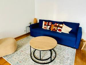 un sofá azul con almohadas y una mesa en la sala de estar. en Luxury flat with parking space, en Châtillon