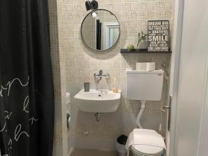 a bathroom with a sink and a toilet and a mirror at City Break Apartments Klishe Zen in Belgrade +28 photos