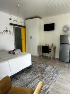 a bedroom with a bed and a kitchen with a table at Villiera Guest Farm in Langebaan