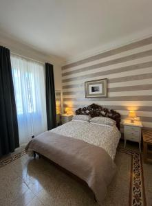 a bedroom with a large bed with striped walls at Affittacamere Perla del Prione in La Spezia