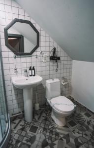 un baño con inodoro y lavabo en Rooftop Grey Apartment at Rustaveli Avenue, en Tiflis 6 fotos más