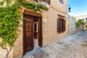 an old building with a wooden door on a street at Muses-Old Town in Rhodes Town
