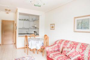 een woonkamer met een bank en een tafel bij Apartamento Samil Primera Línea de Playa 2O in Vigo