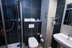 a bathroom with a shower and a toilet and a sink at Hotel SOREA REGIA in Bratislava