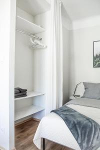 1 dormitorio con paredes blancas, 1 cama y estanterías en A cosy studio apartment in the heart of Tallinn, en Tallin